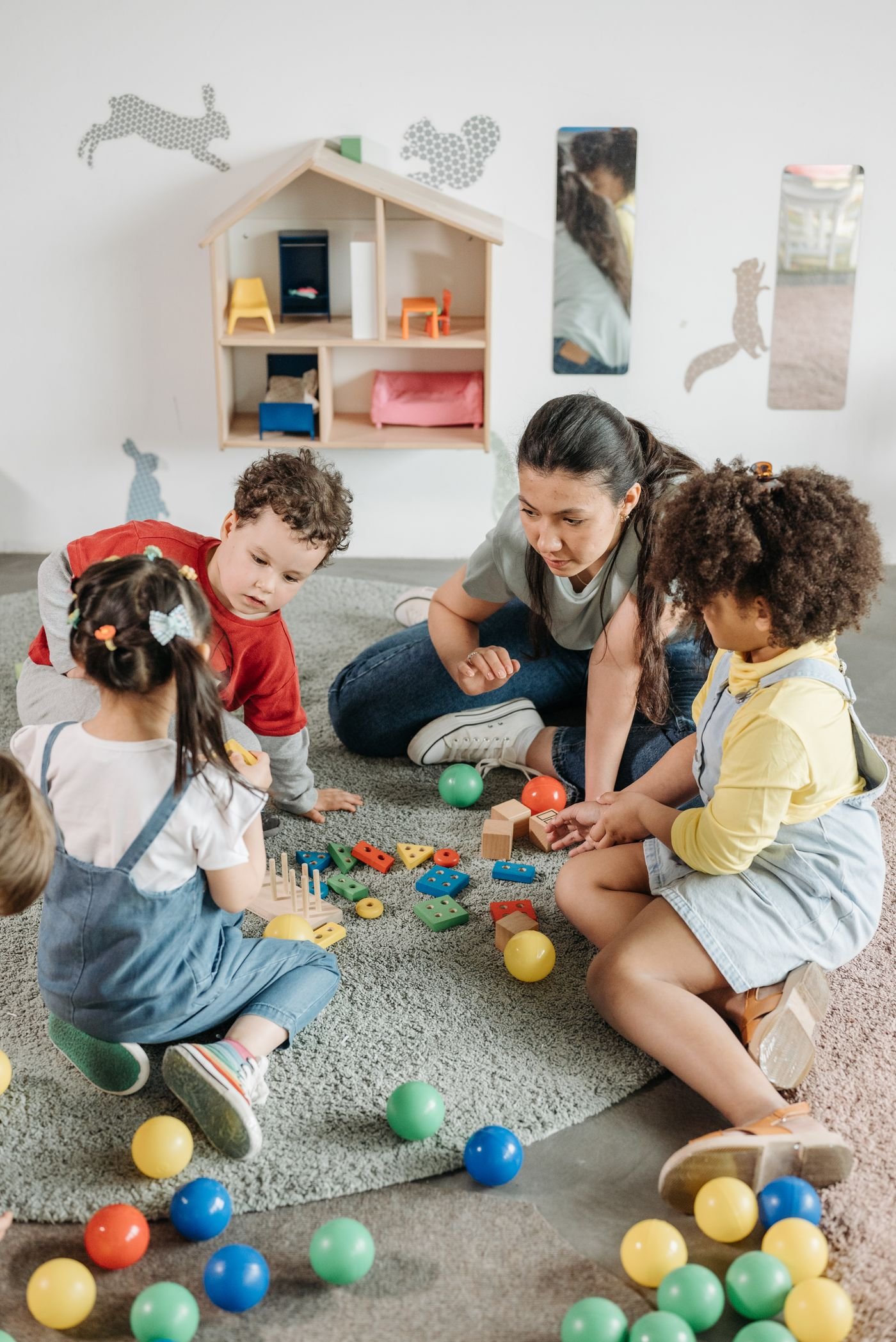 Kinder und Erzieherin gemeinsam am Tisch im Kindergarten