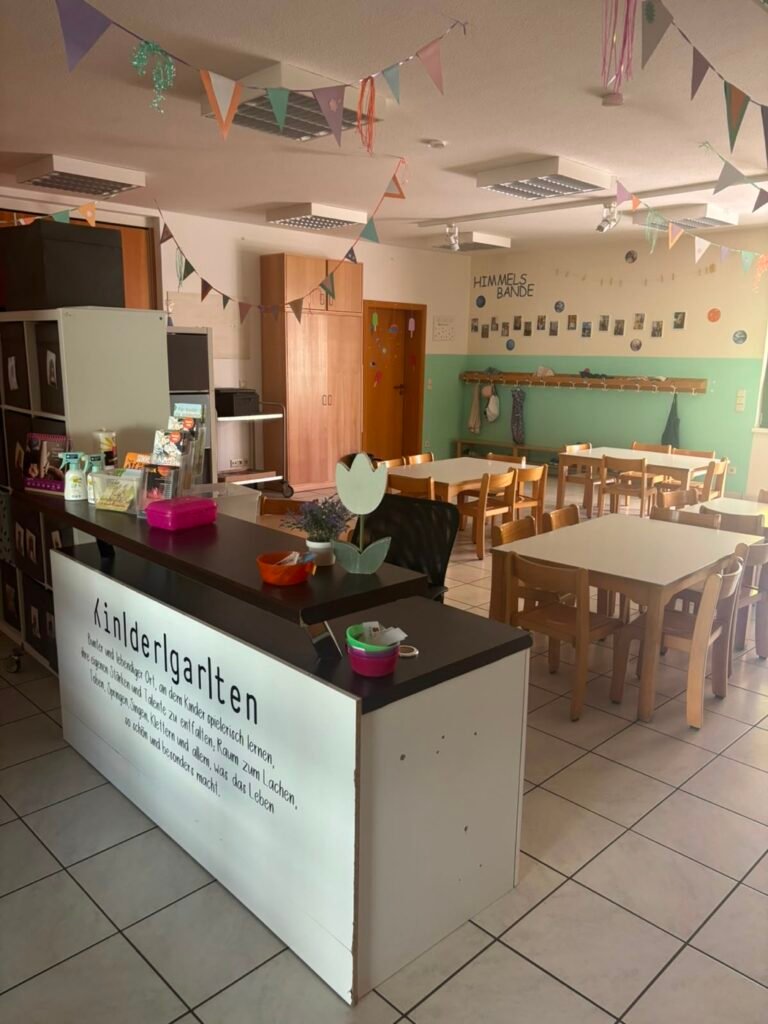 Bistro des Kindergartens mit Kindertischen und Wimpelketten